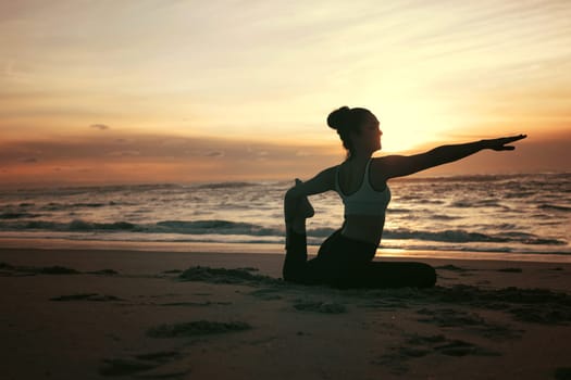 Sporty young woman doing yoga practice at the beach - concept of healthy life and natural balance between body and mental development