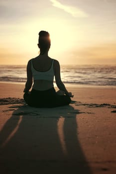 Sporty young woman doing yoga practice at the beach - concept of healthy life and natural balance between body and mental development