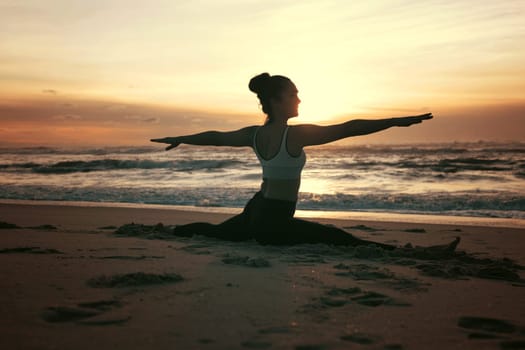 Sporty young woman doing yoga practice at the beach - concept of healthy life and natural balance between body and mental development