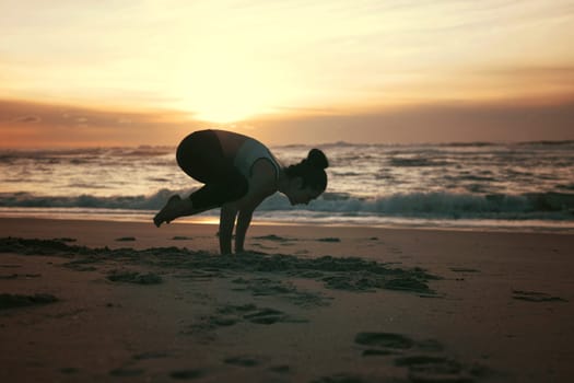 Sporty young woman doing yoga practice at the beach - concept of healthy life and natural balance between body and mental development