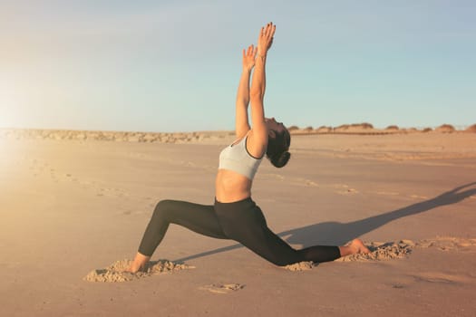 Sporty young woman doing yoga practice at the beach - concept of healthy life and natural balance between body and mental development