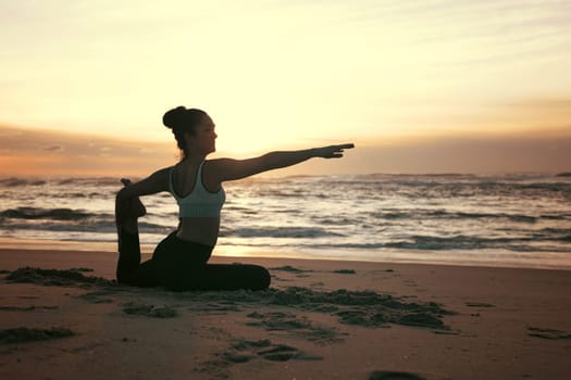 Sporty young woman doing yoga practice at the beach - concept of healthy life and natural balance between body and mental development
