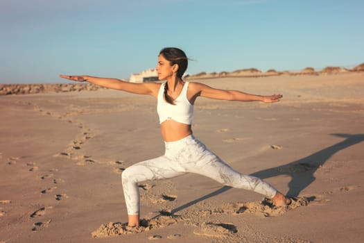 Sporty young woman doing yoga practice at the beach - concept of healthy life and natural balance between body and mental development