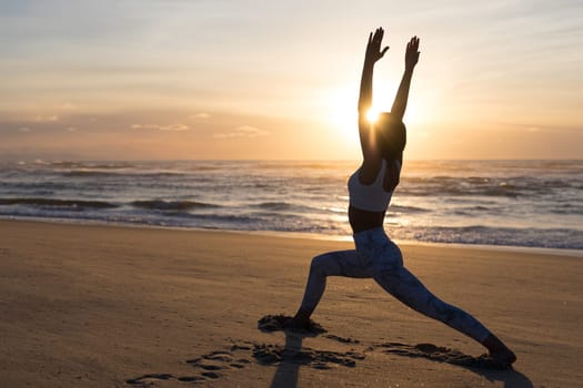 Sporty young woman doing yoga practice at the beach - concept of healthy life and natural balance between body and mental development