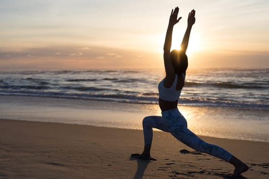 Sporty young woman doing yoga practice at the beach - concept of healthy life and natural balance between body and mental development