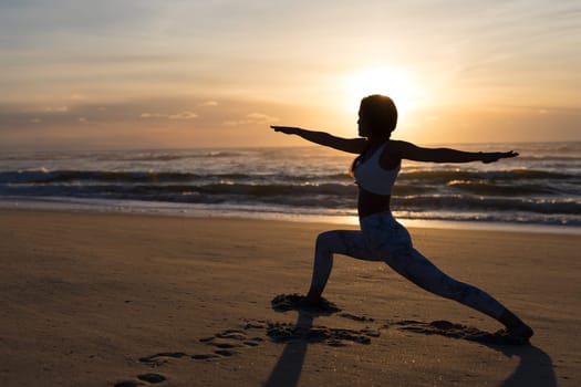 Sporty young woman doing yoga practice at the beach - concept of healthy life and natural balance between body and mental development