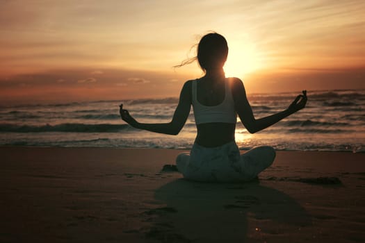 Sporty young woman doing yoga practice at the beach - concept of healthy life and natural balance between body and mental development