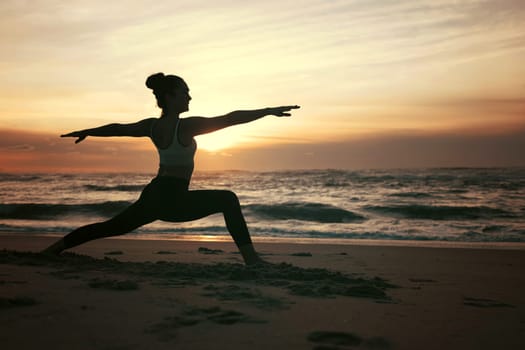 Sporty young woman doing yoga practice at the beach - concept of healthy life and natural balance between body and mental development
