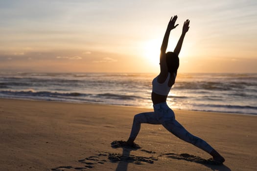 Sporty young woman doing yoga practice at the beach - concept of healthy life and natural balance between body and mental development