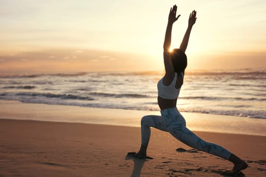Sporty young woman doing yoga practice at the beach - concept of healthy life and natural balance between body and mental development