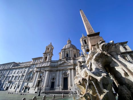 The fountain of the four rivers with the facade of the church of Santa Agnese in Piazza Navona in Rome. Town square. Baroque art. Tourism and travel