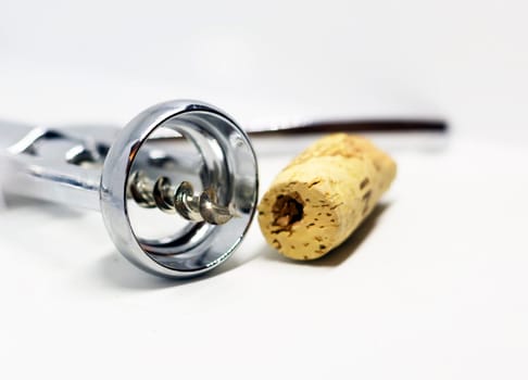 steel wing corkscrew with a perforated cork isolated on a white background.
