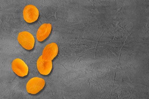 Flying slices dried apricot fruits on creative trendy background. Food levitation concept. Flat lay with copy space.