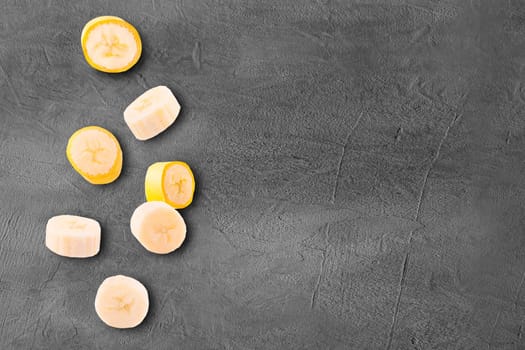 Flying slices banana fruits on creative trendy background. Food levitation concept. Flat lay with copy space.