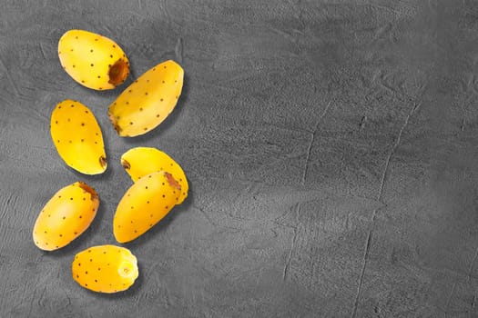 Flying whole yellow prickly pear cactus fruits on creative trendy background. Food levitation concept. Flat lay with copy space.