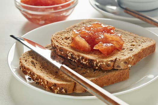 Breakfast. Still life from appetizing  toasts with apple jam and cup of coffee on white background.  Selective focus on toast with jam