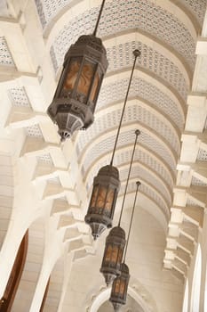 Oriental hanging lamps in the archway of the Sultan Qaboos Mosque in Muscat.