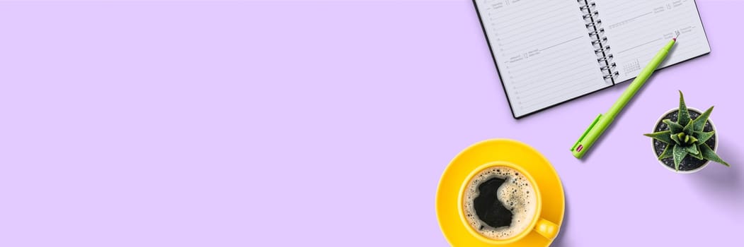 Top view of a workplace with office supplies on a lilac background