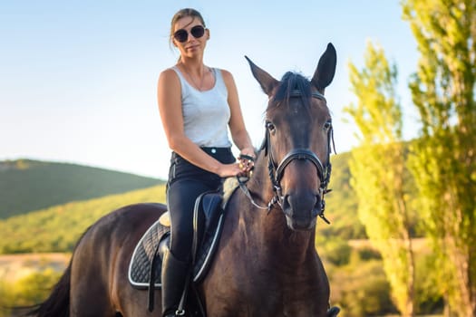 Girl with glasses on a horse ride in the autumn forest