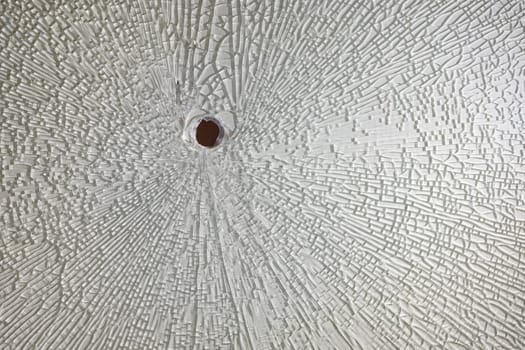 Cracks around the hole in the broken tempered glass