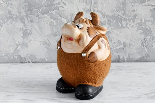 Clay bull figurine in black and white decorated with Christmas decorations on a white background. New year of the bull
