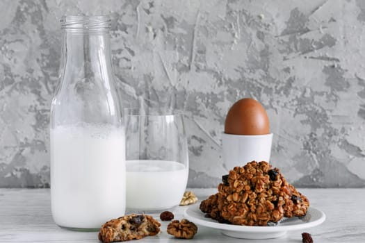 Milk in a bottle on the table at breakfast with oatmeal cookies