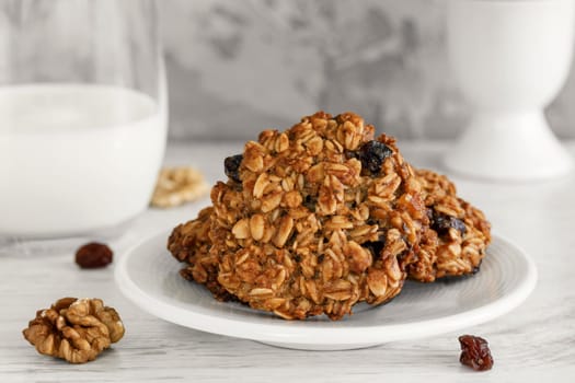 Oatmeal cookies on a saucer close-up with a glass of milk