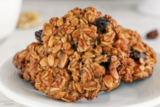 Oatmeal cookies on a saucer close-up with light brown raisins