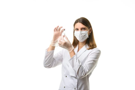 Girl doctor stands with a glass test tube in her hands