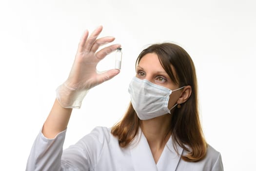 Doctor looks closely at the drug in a test tube, focusing on the test tube