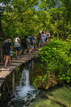 Plitvicka Jezera, Croatia, July 2019 Crowd of tourists walking on boardwalk in stunning Plitvice Lakes National Park, a UNESCO World Heritage site