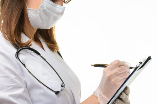 Doctor writes with a pen in a tablet computer on a sheet of paper, close-up