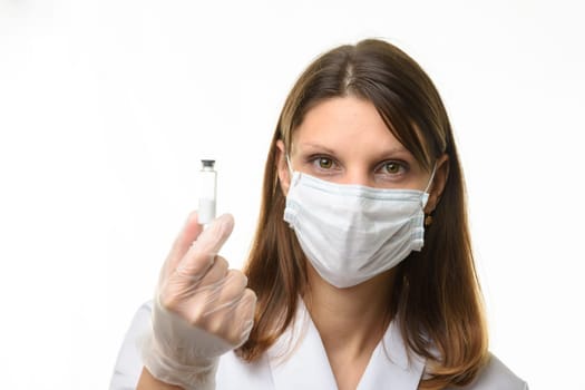 Girl doctor holding a glass tube with white powder in her hands