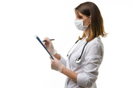 Girl doctor writes with a pen in a tablet computer on a sheet of paper