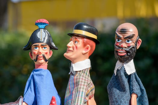 colorful puppets on a dark background, the devil, the policeman, the man