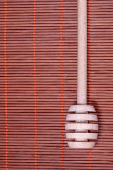 Wood Honey spoon on a nice wicker carpet as background