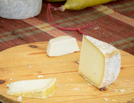 Italian cheeses for sale to the market on a wooden cutting board ready to be tasted