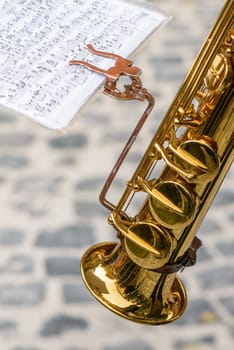 Musical score in front of the players of a country band, visible part of the instrument