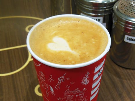 Cafe latte in cup with white foam heart shape