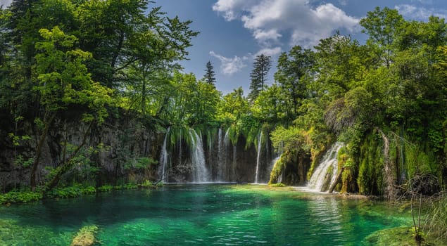Amazing panorama with waterfall, water coming down from lichens to turquoise coloured lake. Plitvice Lakes National Park UNESCO World Heritage Croatia
