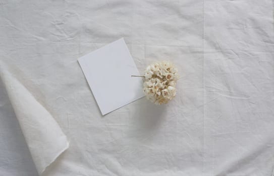 White paper and whit flower on white fabric , decoration background