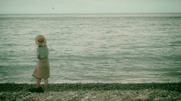 The Girl throwing stones at the beach