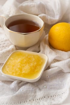 Healthy bowl of pure honey with honey dipper and lemon fruit and puree on vintage white background. Vertical image