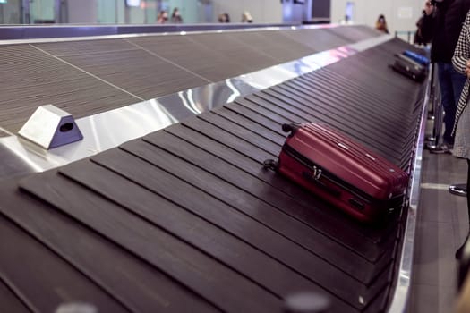 Suitcase on luggage conveyor in the baggage claim area at the airport. Lockdown