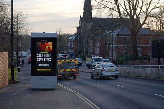 Sheffield, United Kingdom, 12th January, 2021: Close up of coronavirus guidance bill board at the side of busy upper hanover street. Cars drive by
