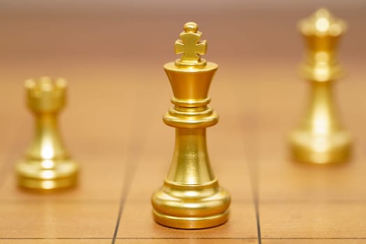 Gold king chess piece and various chess pieces stand on wood chessboard ,Concept of leadership game of strategy