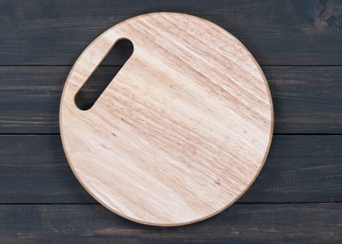 Wooden round empty cutting board on a wooden table close up