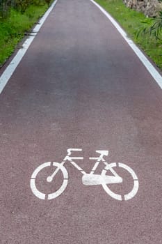 Cycle path with road signs in the woods. Foreground and depth of the horizon.