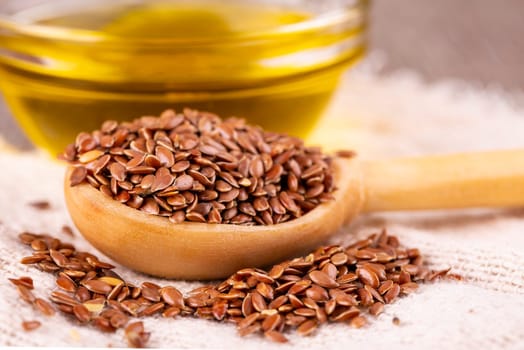 Brown flax seeds and flaxseed oil on a wooden surface