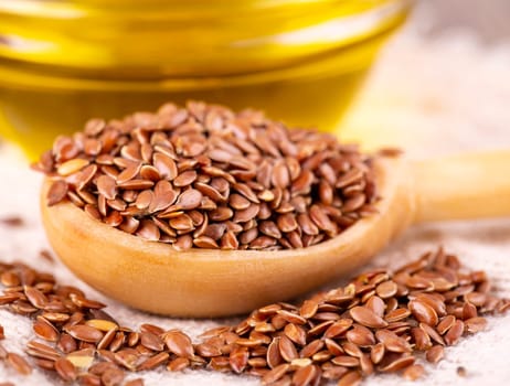 Brown flax seeds and flaxseed oil on a wooden surface